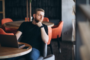 Beraded man working on laptop in a cafe - Świat notebooków Delegacje oraz podróże firmowe rządzą się swoimi prawami